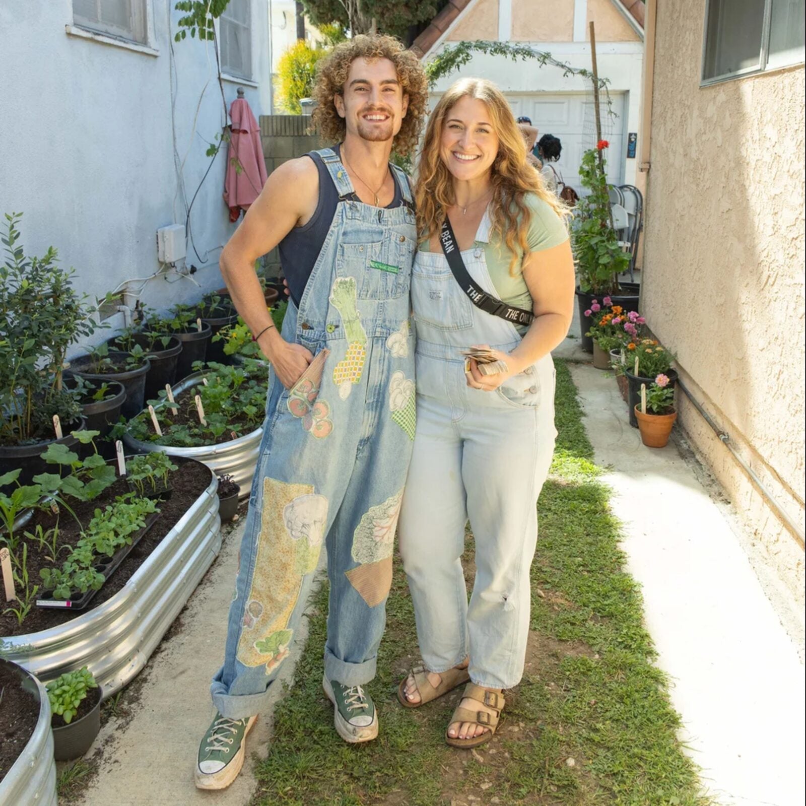 Couple in overalls in an urban garden